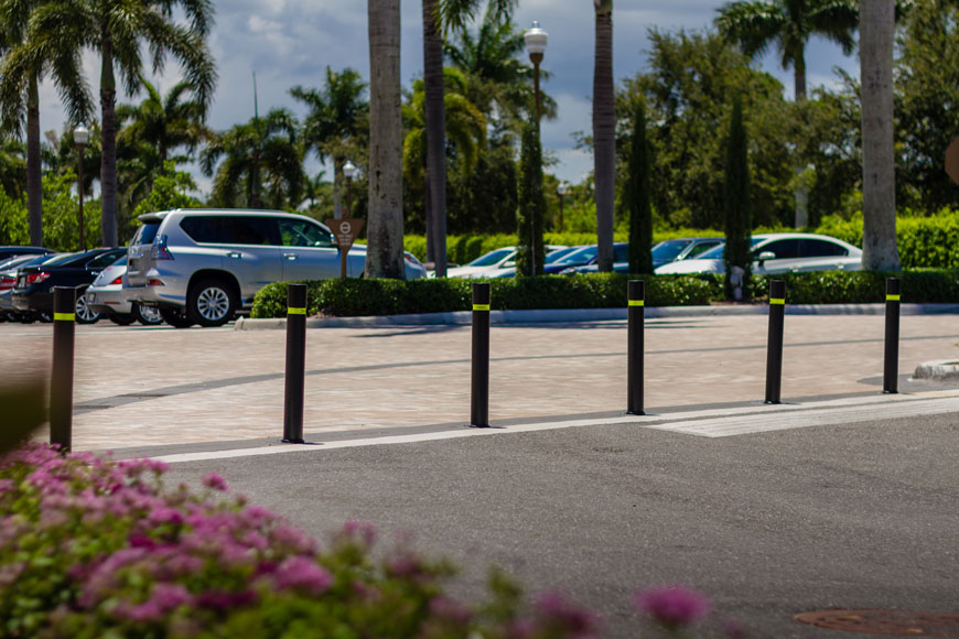 A line of black removable bollards creates variable access space