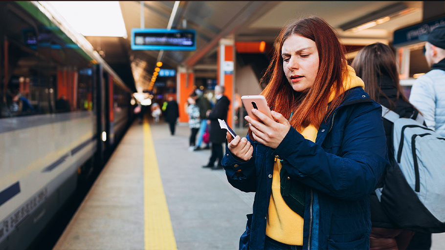 a distracted woman stands on a train platform