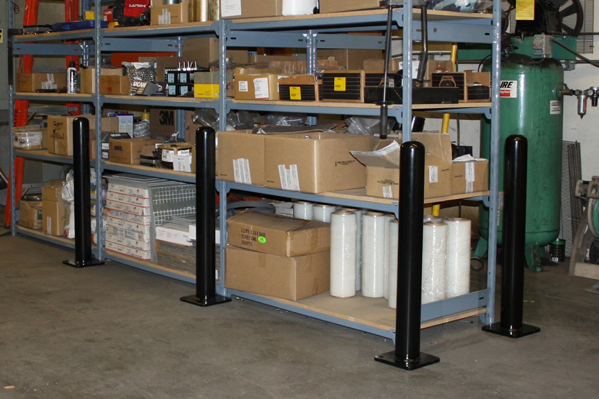 a perimeter of bolt down bollards protect warehouse shelving