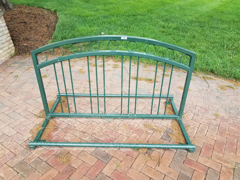 A pretty green grid rack on a brick walkway