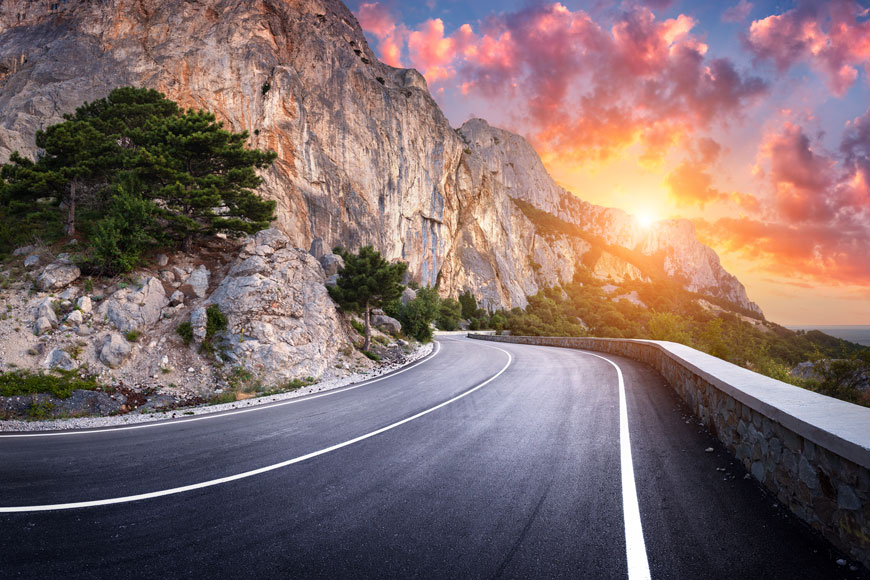 Winding asphalt road at sunset