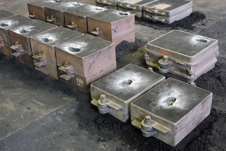 Green sand molds on a foundry floor prepared for casting