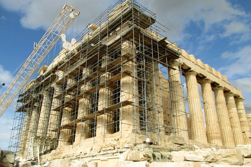 An image of the many Doric columns of the Parthenon surrounded by a nest of scaffolding for restoration work