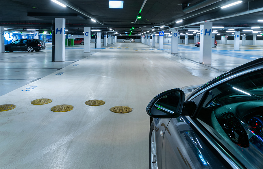 A black car maneuvering through an underground parking lot