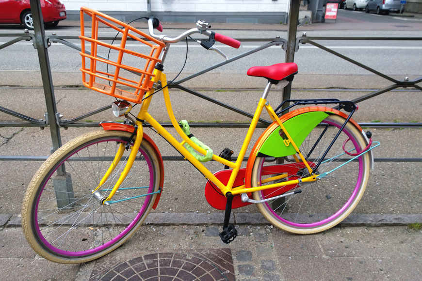 Bicycle painted various colors parked on the street