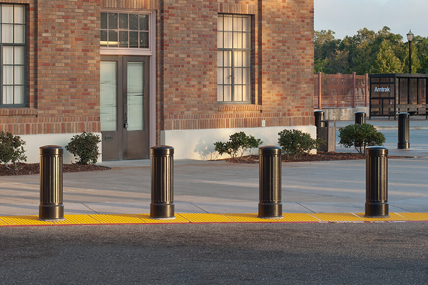 Four bollards in a line protect pedestrians from accidental contact